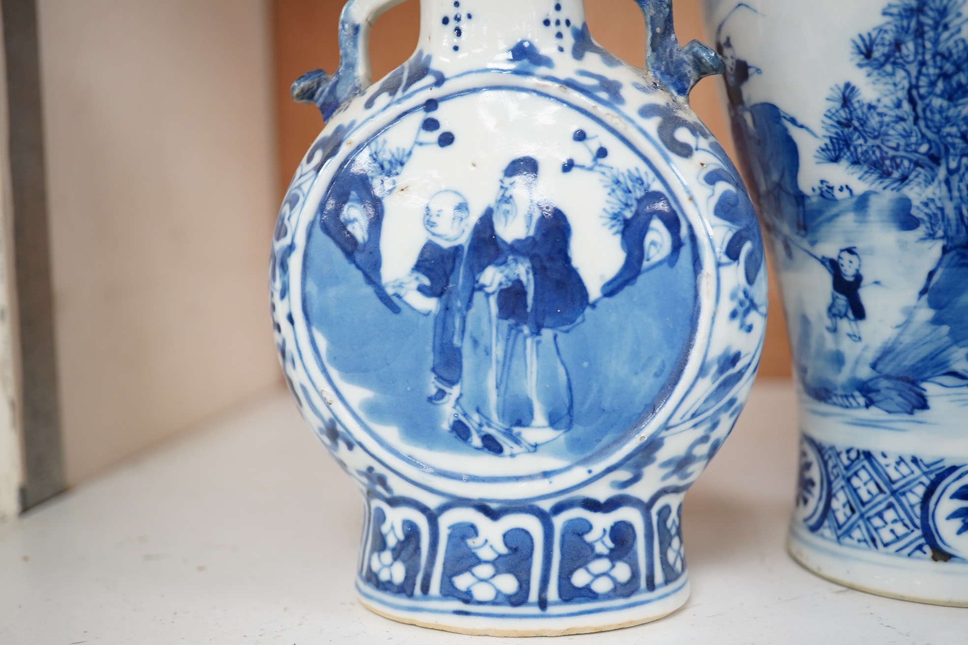 Late 19th century Chinese vases; pair of small Chinese blue and white moon flasks and a larger Chinese blue and white landscape vase, larger vase 22cm high. Condition - one moon flask handle restored, other items fair